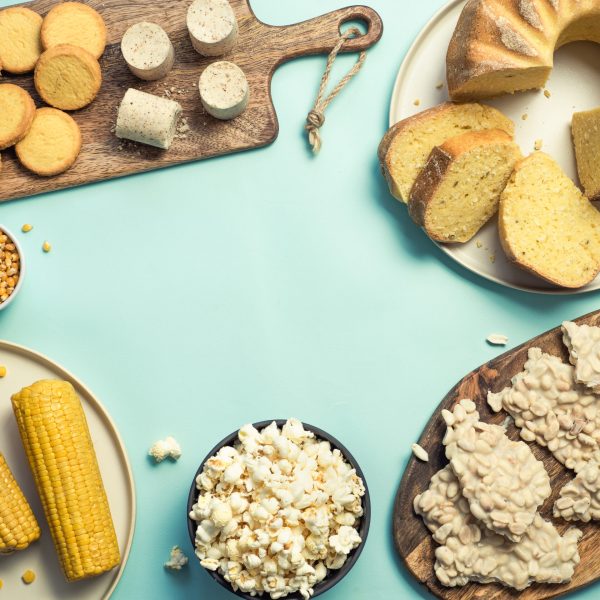 Festa Junina traditional food background,copy space for text. Delicious sweets for Brazilian Festa Junina Party: cornmeal cake Bolo de Fuba, corn cookies,popcorn,peanut candy Pacoca, corn ear top view